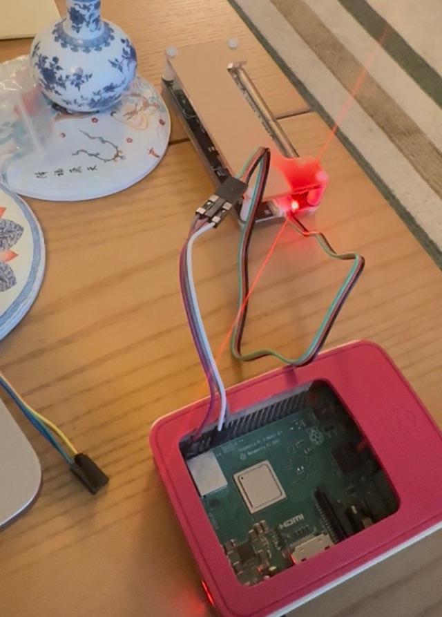The Geiger counter module with its glass tube, wired with jumper cables to a Raspberry Pi in a pink case